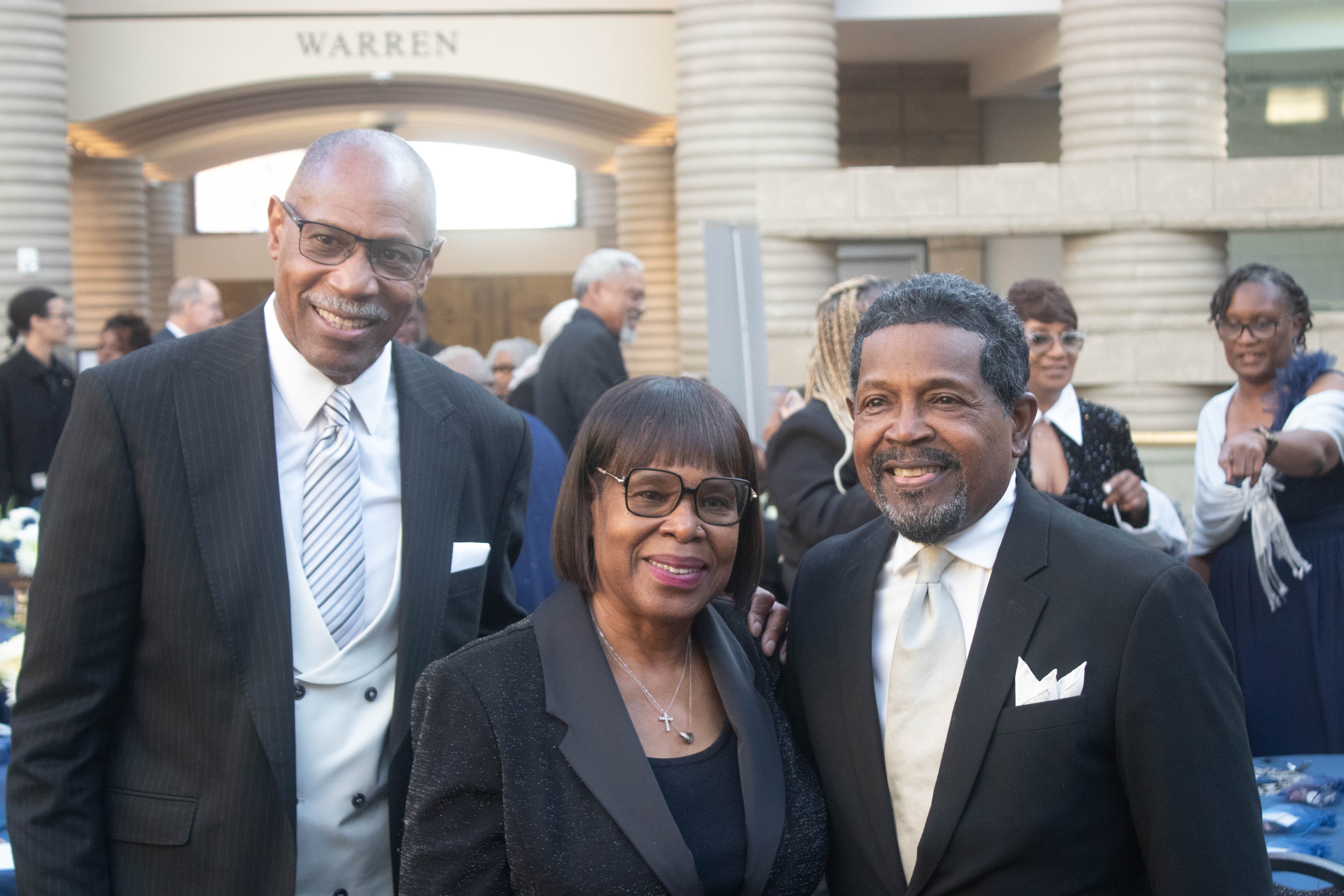 Three people in formal attire at event