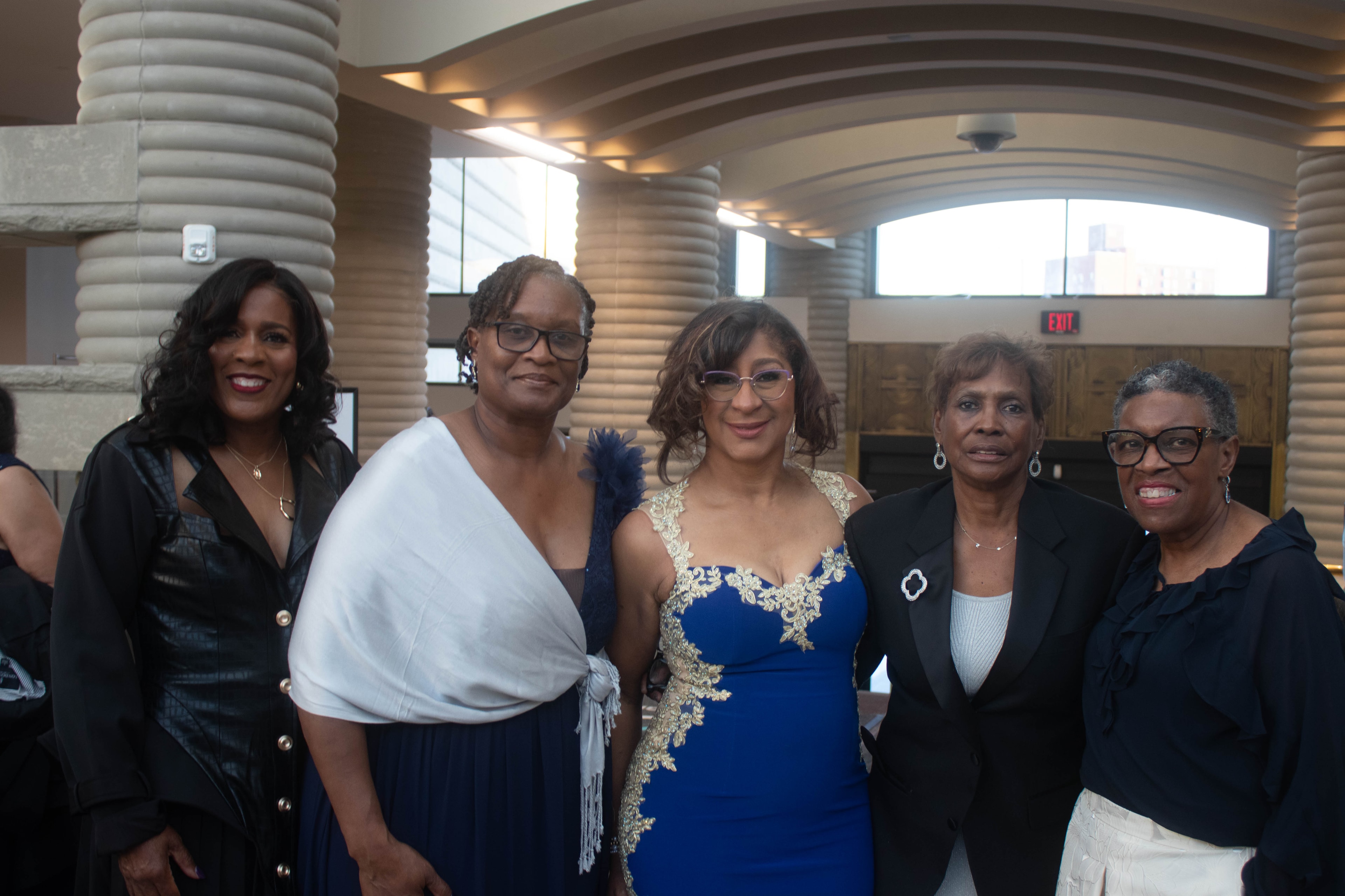Five women posing together indoors