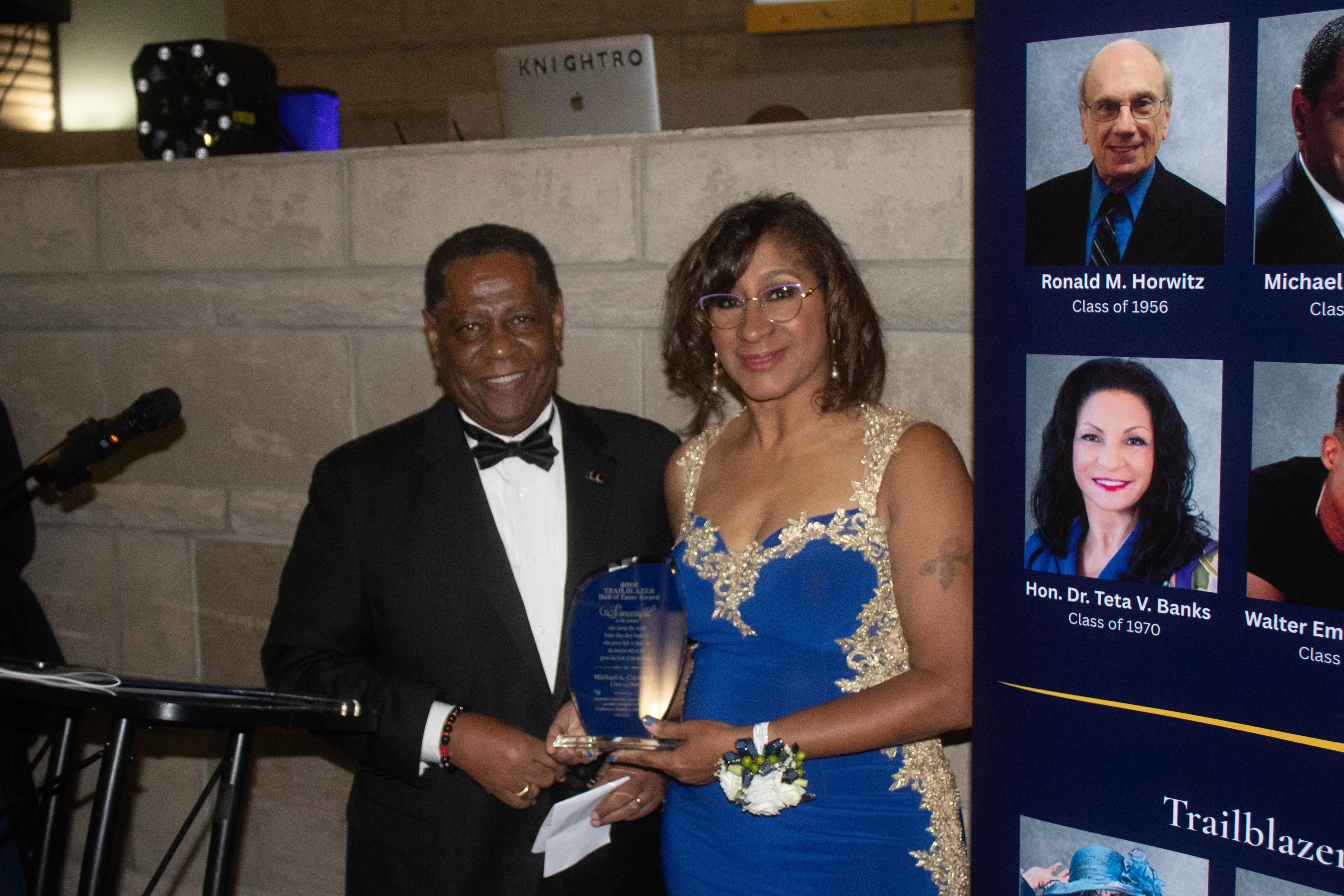 Couple receiving award at formal gala event